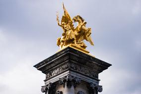 golden statue on a column in paris