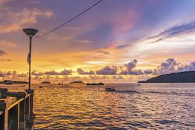 Beautiful waterscape, from the pier, at colorful sunset in the sky with clouds