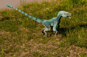 Model of the turquoise dinosaur, on the green grass