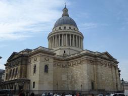 Beautiful, decorated building with the dome, at blue sky and white clouds on background