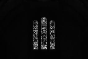 Black and white photo of the beautiful, patterned windows in the church in Azores, SÃ£o Miguel, among the darkness
