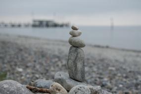 a small tower of stones on the beach by the sea