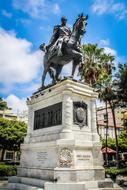 Beautiful statue of Simon Bolivar, on the horse, among the colorful plants