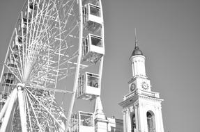 Black and white photo of the beautiful Ferris wheel and tower with clock