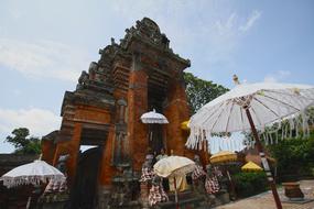 Beautiful landscape with the colorful temple and white, decorated umbrellas on Bali, Indonesia