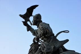 Beautiful monument of the man, with the bird, in Menton, France, at blue sky on background