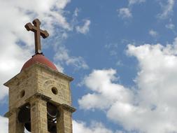 Beautiful church top with the cross, at blue sky with white clouds on background, in Israel