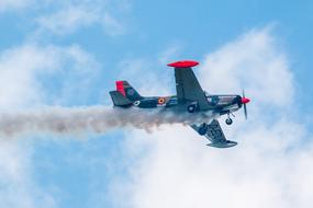 Beautiful and colorful, flying Sf 260 Marchetti aircraft, at blue sky with white clouds on background