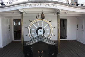 Beautiful, white steering wheel on the wheelhouse, with the sign