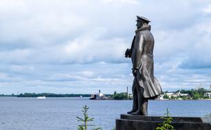 Beautiful sculpture of sailor, on the shore of the sea, and cityscape