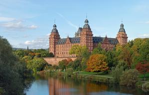 Beautiful Schloss Johannisburg among the colorful trees near the water in Aschaffenburg, Franconia, Bavaria, Germany