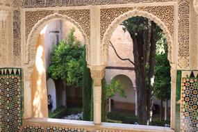 Beautiful and colorful windows of the Alhambra palace in Granada, Spain, with the green plants