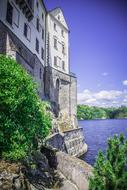 Beautiful castle on the coast with green plants, on landscape