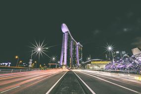 Beautiful road, with the colorful lights in motion, with the Marina Sands Bay in Singapore, at the night