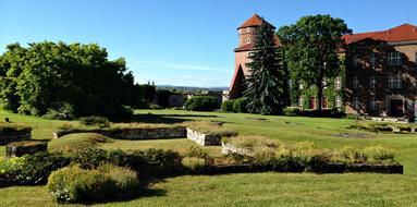 Beautiful and colorful Wawel Castle, among the colorful plants, in KrakÃ³w, Poland