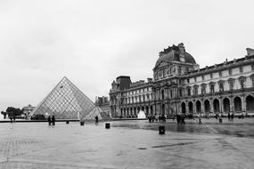 Black and white photo of the beautiful Louvre, among the square in Paris, France