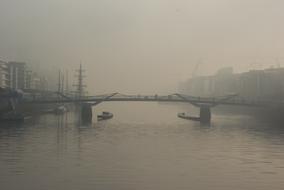 Beautiful, foggy landscape with the bridge, above the river, among the buildings