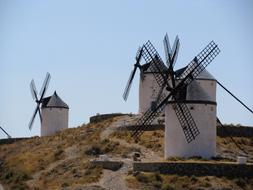 Beautiful, white mills on the colorful hill in Castile La Mancha, in Spain