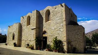 Beautiful Panagia Stazousa monastery of Byzantine with green plants, at blue sky with white clouds on background, on Cyprus, Greece