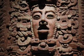 Beautiful, carved face in the museum in light in Mexico