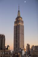 Skyscraper, with the colorful lights, among the other buildings, in New York, USA, at colorful, gradient twilight