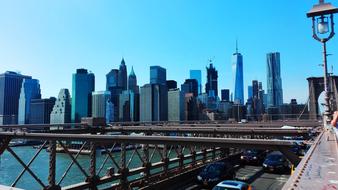 New York cityscape from the Brooklyn Bridge with cars, at blue sky, in USA