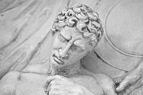 Beautiful, white statue of a man with curly hair, in the temple