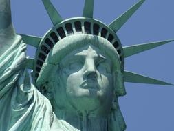 head of the statue of liberty close-up against the blue sky