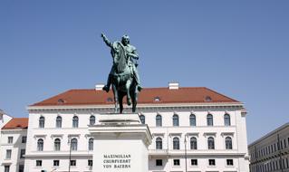 statue on horseback near a historic building on a sunny day