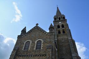 Beautiful Church Tinteniac, with the bell tower, in sunlight, in Brittany, France, under the blue sky, with clouds