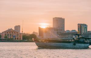 boat on Water at Sunset in view of city