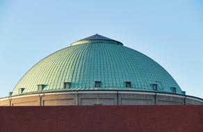 Beautiful building with green dome at blue sky background