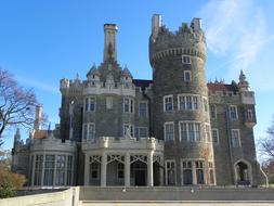 Beautiful Casa Loma, among the colorful trees, in Toronto, Canada, under the blue sky with white clouds