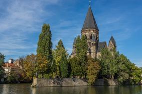 old Church on waterside among green trees, france, metz