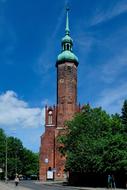 Colorful and beautiful church, with the green dome, in Slupsk, Poland, among the green trees