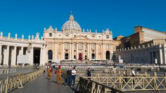 people walking along fences in front of St Peterâs Basilica, italy, rome, vatican