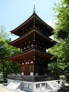 Beautiful and colorful Three-story Pagoda in Okadera, Japan, among the green trees, under the blue sky