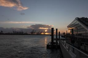 View of the port of Hamburg, Germany, at colorful sunset with clouds