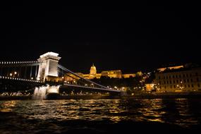 view from the water to the bridge in budapest at night