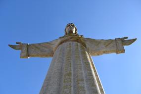 Low angle shot of the beautiful Cristo Rei Statue in Lisbon, Portugal, under the blue sky