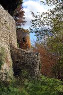 stone walls of a medieval castle among the trees