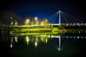 night illumination and reflection in the water of the suspension bridge