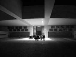 Black and white photo with people in light, near the building in Fatima, Portugal