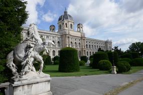 Beautiful landscape with the castle and statue, among the green plants in Vienna, Austria