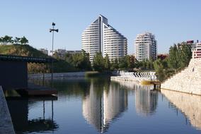 Park with the lake and plants, near the buildings in Valencia, Spain, under the blue sky