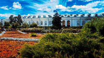 Beautiful landscape of the building among the colorful plants, in Moscow, Russia, under the blue sky with white clouds