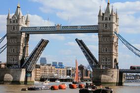 a sailing ship sails under the tower bridge in London