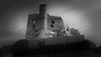 black and white photo of the castle ruins on the hill