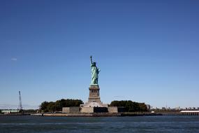 distant view from the water to the Statue of Liberty on a sunny day