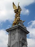 Beautiful, gold Victoria Monument in London, England, under the blue sky with white clouds